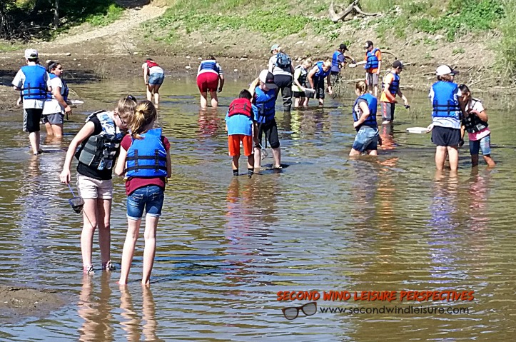 Middle school kids avert danger by wearing life jackets even in knee-deep water.