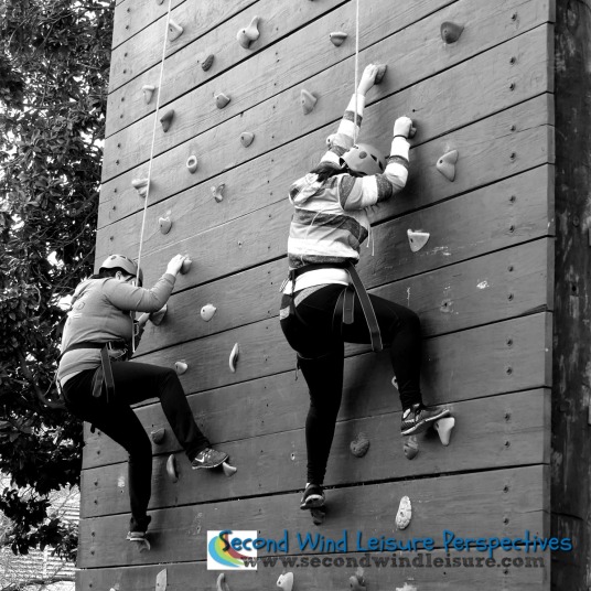 Students carefully "walk" their feet on the climbing wall.