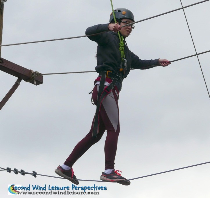 Sac State student deftly walks the high ropes course at the Challenge Center.