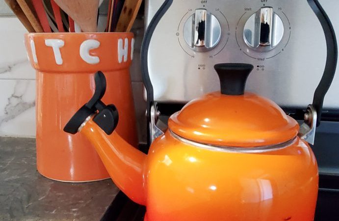 Smiling orange teapot